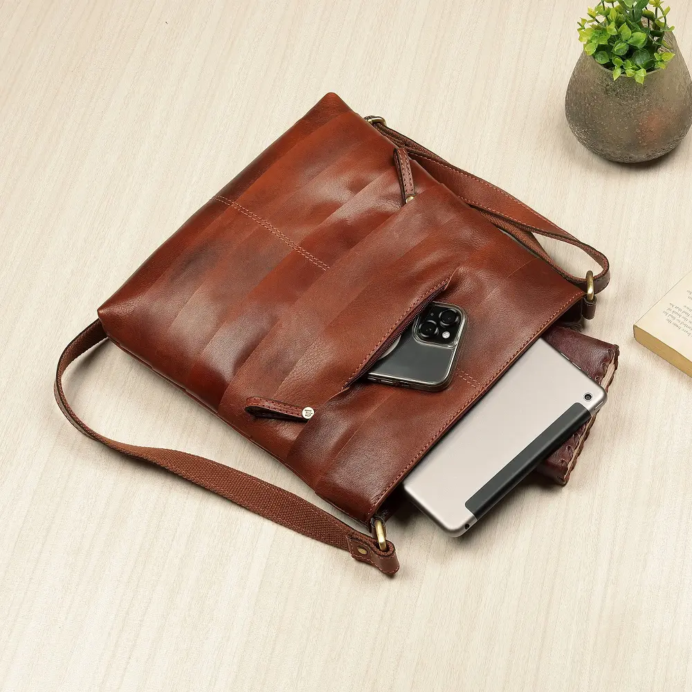 Leather Crossbody Bag Ridgeback-4 Interior view of the Boho Layered Leather Bag - Ridgeback with a phone and tablet partially visible, highlighting its spacious compartments and practical organisation.