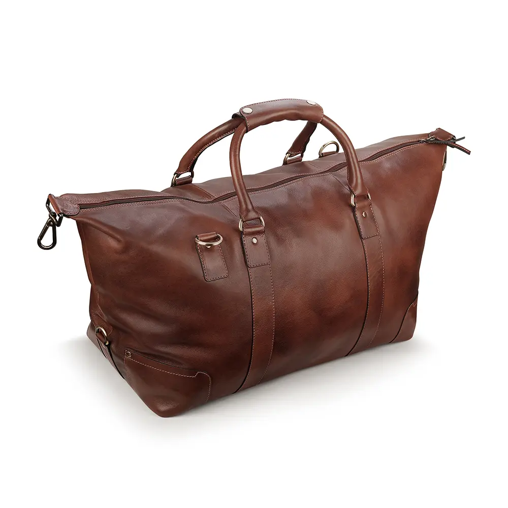 Angled view of the brown leather holdall, emphasizing its spacious design and reinforced stitching.