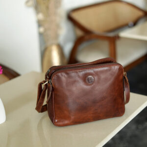 A spacious brown leather handbag for women, styled on a work desk