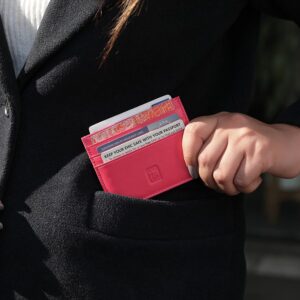 Pink Personalised Leather Card Holder with RFID 04 Person placing a pink leather card holder into their coat pocket