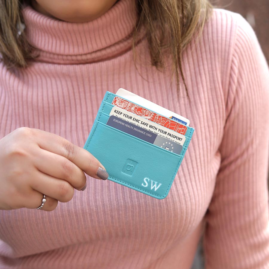 Turquoise Personalised Leather Card Holder with RFID 01 Woman in pink jumper holding turquoise personalised leather card holder with initials
